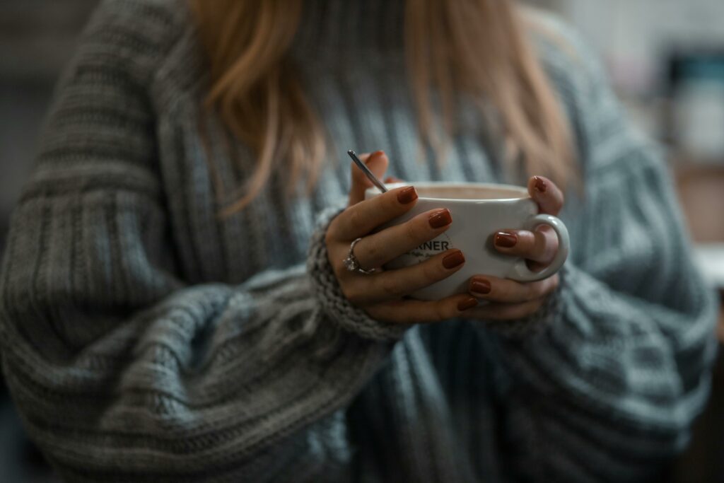 tips on how to reduce costs this winter.
person warming up with a cup of tea